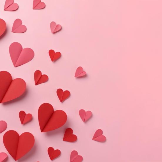 Lyserød baggrund med røde papirhjerter.