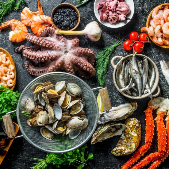Bord med lækker mad fra havet, heriblandt muslinger, blæksprutte, fisk, rejer og krabbe.