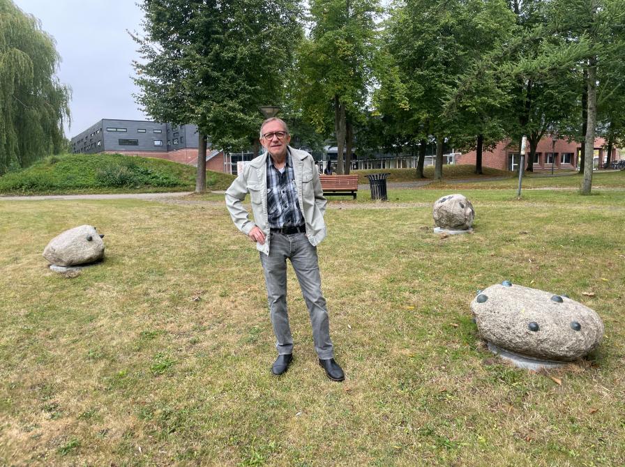 Foto af billedhugger Geert D. Funder med Solrød Bibliotek og Kulturhus' Bibliotekshaves nye stenskulpturer.